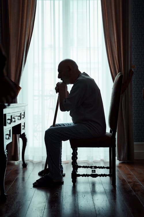 an elderly man sitting on a chair