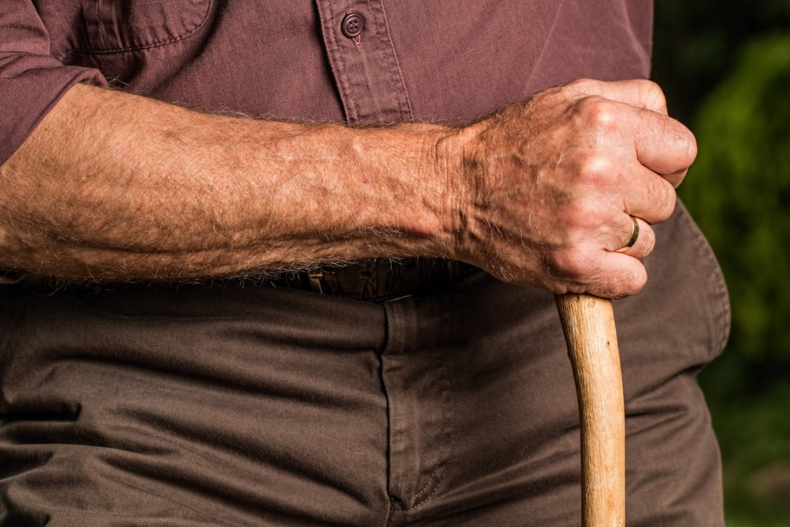 an old man holding a wooden cane