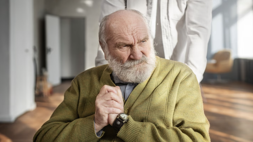 Man showing frustration while struggling with hand tremor