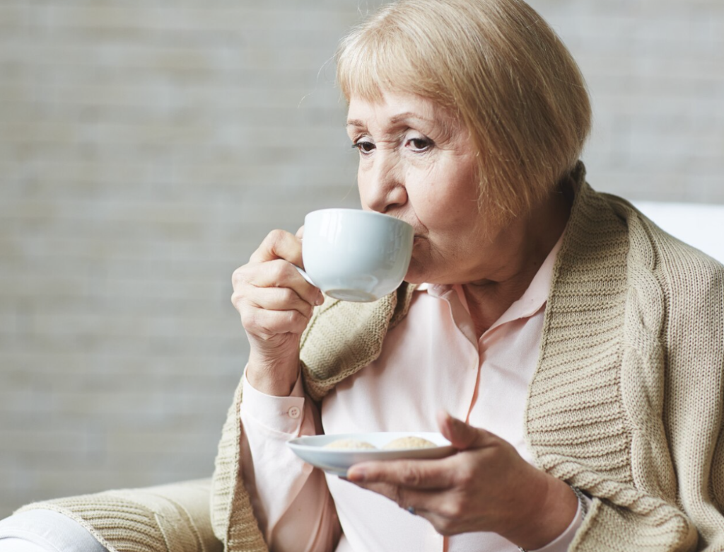 Older woman drinking coffee at home