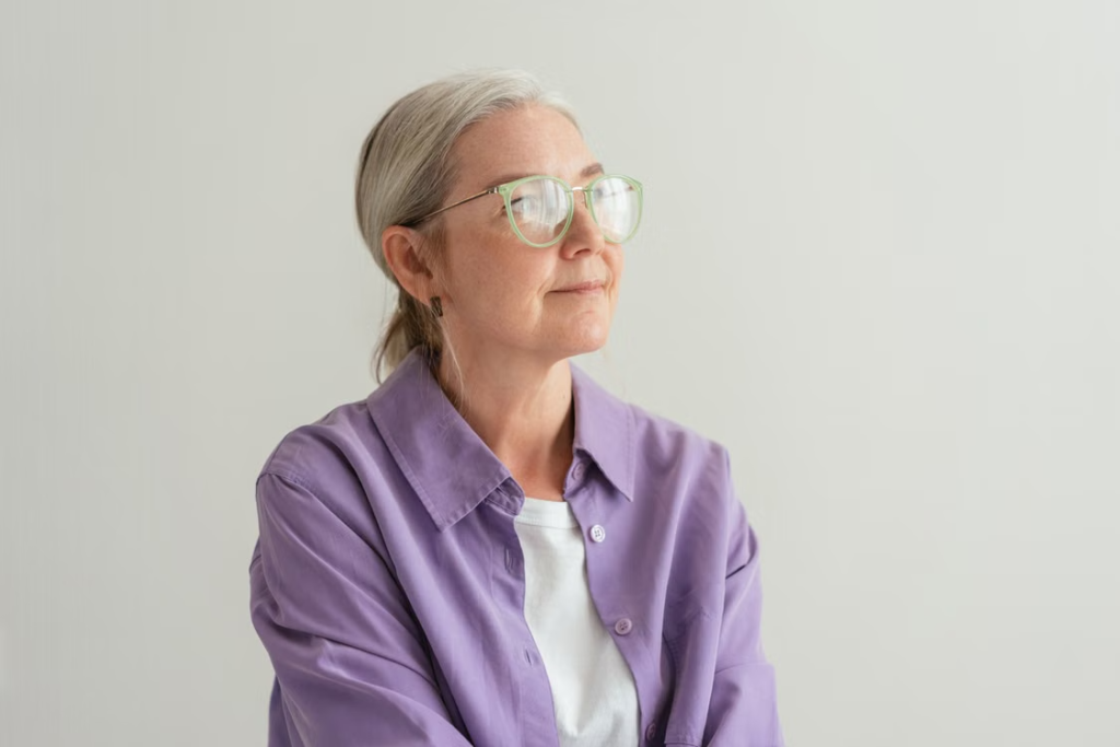 Older-woman-reflecting-on-subtle-changes-that-may-be-early-signs-of-a-movement-disorder.webp