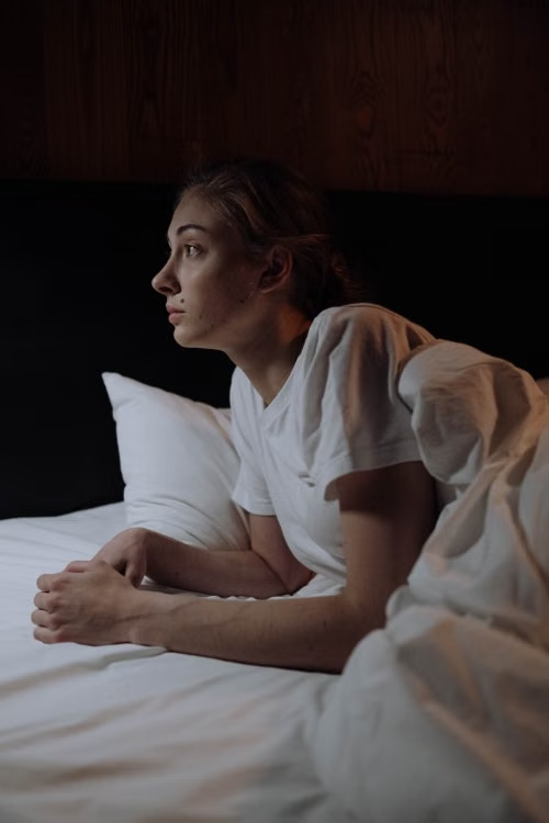 a-woman-in-a-white-shirt-trying-to-sleep.webp