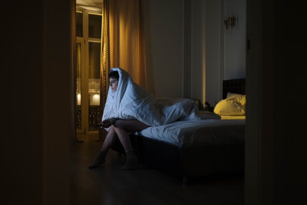 a-woman-sitting-in-bed-struggling-to-sleep.webp