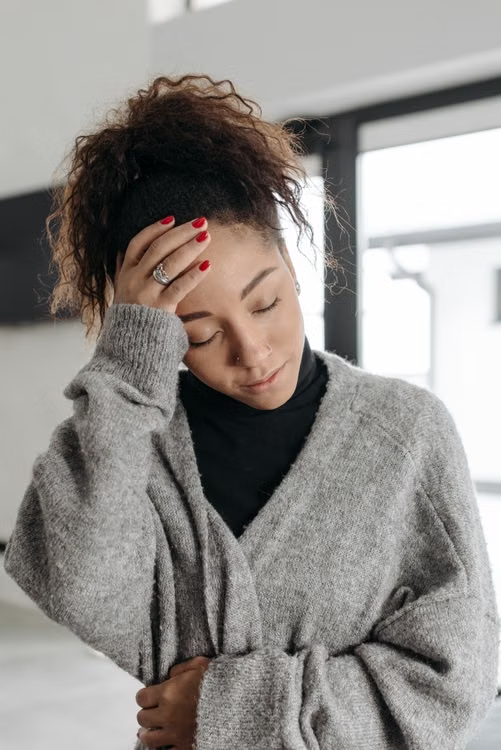 woman-gray-sweater-headache.webp
